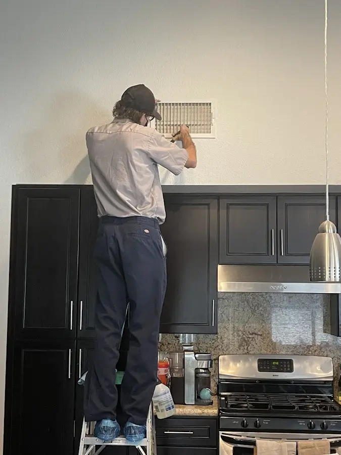 Technician inspecting an air vent during HVAC service in Mechanicville
